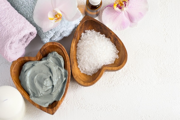 Spa background. Cosmetic face and body mask  made of blue clay, sea salt towels and orchids