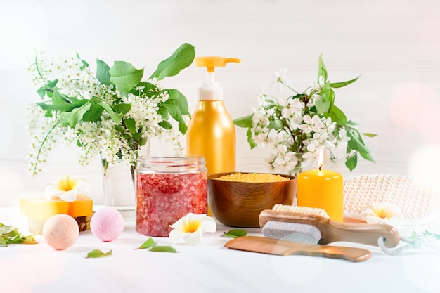 Spa and bath accessories with bath salts and beauty treatment products on white table. Wellness concept