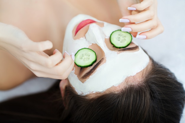 Spa. Beautician applies the mask to the face of beautiful young woman in the spa salon. spa treatments