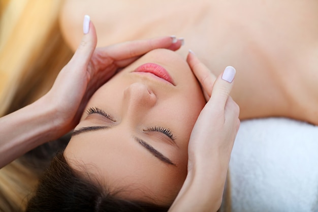 Spa. Beautiful Young Woman Getting a Face Treatment at Beauty Salon.