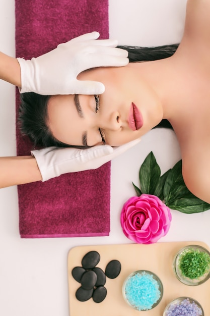 Spa, beauty, people and body care concept - beautiful woman getting face treatment