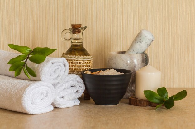 Spa, beauty and wellness towel, cosmetic massage oil, fresh leaf, sea salt with shells and candle