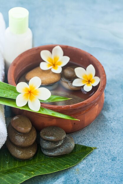 Spa bloemen en stenen en cosmetica voor massagebehandeling op blauwe achtergrond