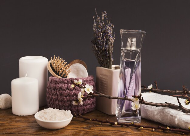 Composizione spa di bottiglie con oli essenziali, aromatici, profumi e fiori spa. aromaterapia a sfondo grigio, vista laterale, copia spazio