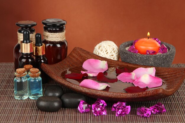 Spa composition with aroma oils on brown background