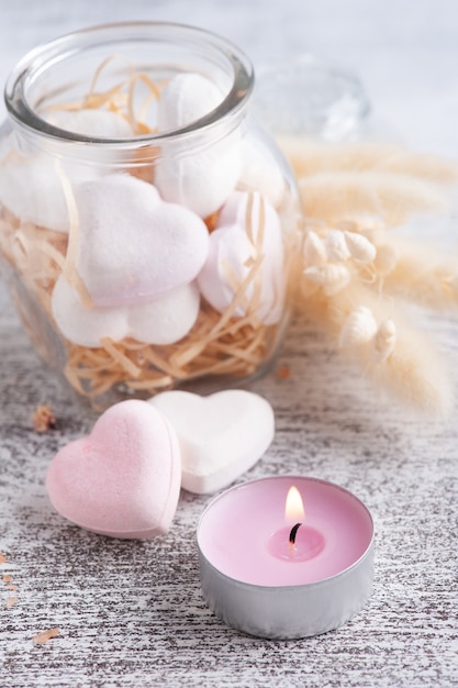 Photo spa composition with bath bomb hearts and dry flowers on rustic background in monochrome style. candles and salt. beauty treatment and relax