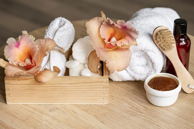 Spa composition with body care products in a wooden box and thai orchid flowers