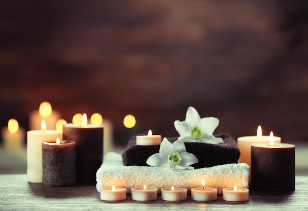 Spa composition with candles on brown background