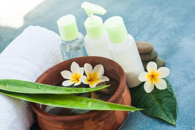 Spa composition with stones and sulight for massage treatment on blue background