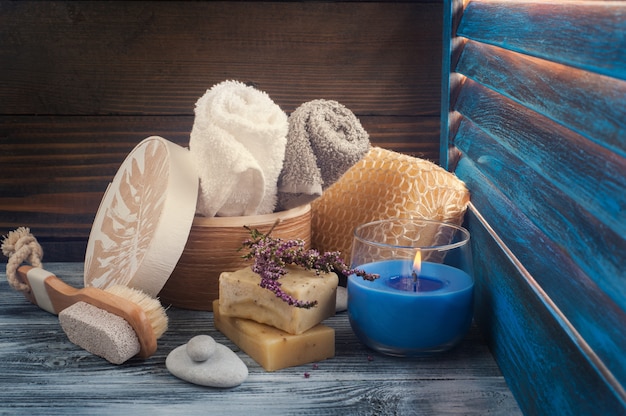 SPA composition with towels, soap, brush, lit candle