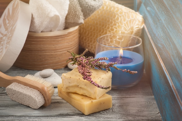 SPA composition with towels, soap, brush, lit candle