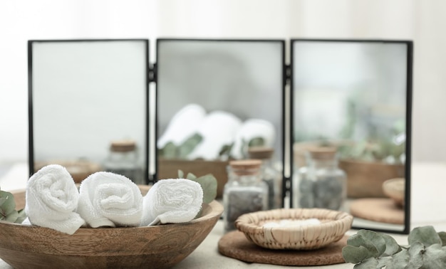 Spa composition with towels in a wooden plate on a blurred background