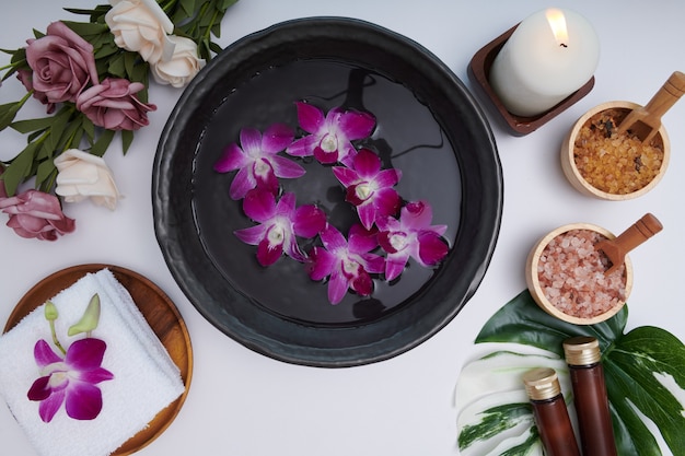 Spa concept. schoonheid en mode-concept met spa-set. geparfumeerd bloemenwater. ontspanning en zen, spa-omgeving plat met kom, badzout en bloemen, handdoek en natuurlijke zeep. bovenaanzicht.