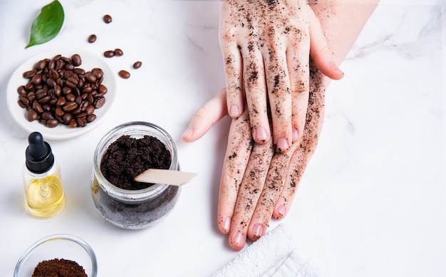 Photo spa concept. a young woman does a hand massage with a homemade coffee scrub