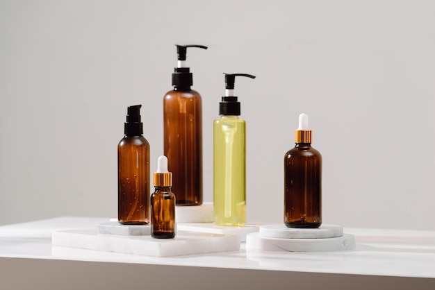 spa cosmetics in brown glass bottles on gray concrete table. copy space for text. beauty blogger, salon therapy, branding mockup, minimalism concept
