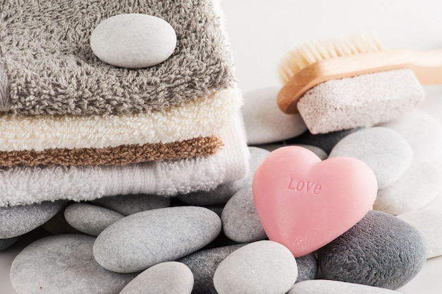 spa elements with towels, pink heart soap and pumice