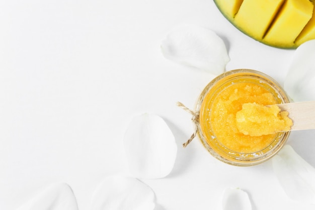 Spa en massage cosmetisch product met rijpe mango op een witte tafel met kopieerruimte bovenaanzicht