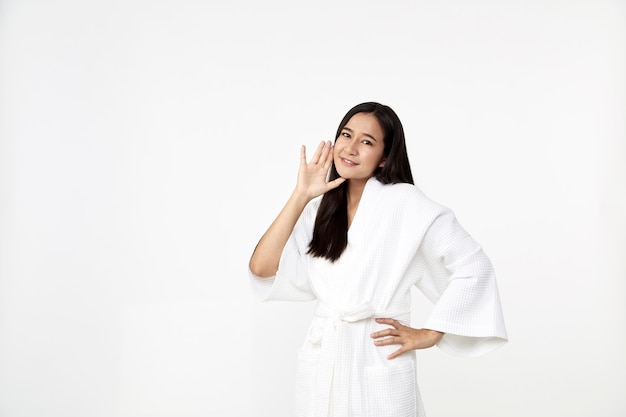 Spa huidverzorging schoonheid Aziatische vrouw draagt ?? een badjas met een glimlach wat betreft zachte huid geïsoleerd op een witte achtergrond