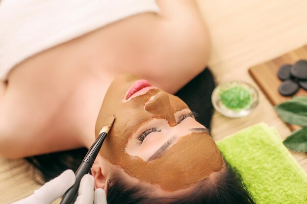 Spa-masker. Vrouw in kuuroordsalon. Gezichtsmasker. Gezichtsklei masker.