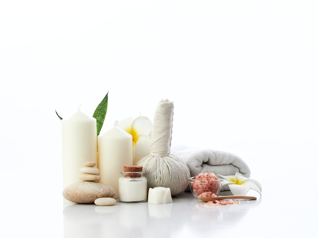 Photo spa massage concept, herbal compress ball, cream, flower soap, scented candle and himalayan pink salt, isolated