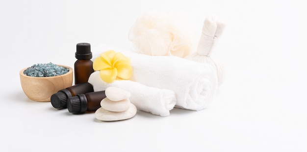 Spa massage, exotic tropical plumeria flowers, serum,herb scrub,zen stones, white towels and blue salt crystal on white