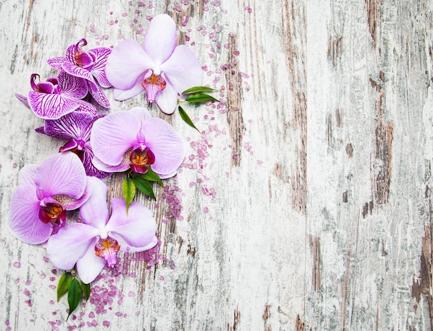 Spa and massage products with orchids on a old wooden background