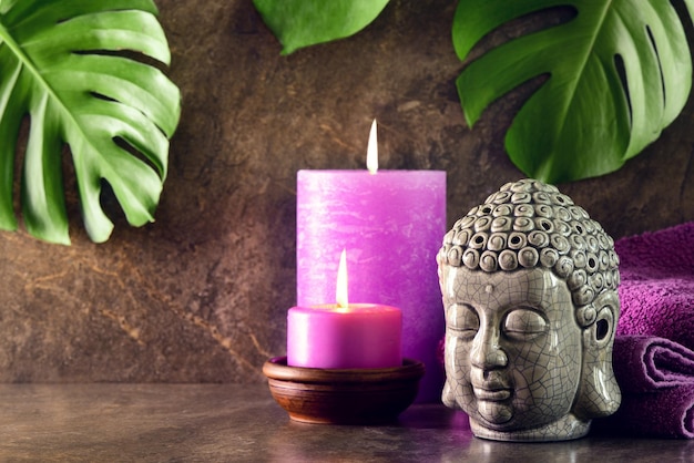 Foto spa e massaggio rilassante con candele aromatiche e concetto di statua della testa di buddha, vista frontale, spazio per un testo