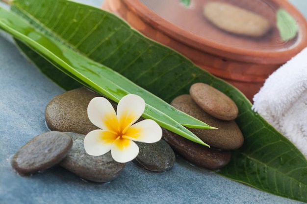 Spa natural composition with stones towel leaves and white flower