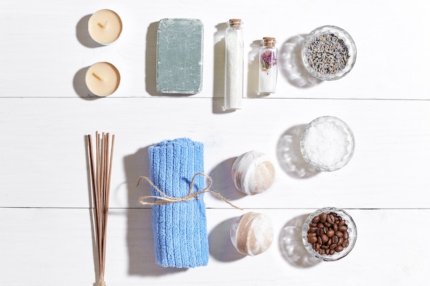 Foto prodotti termali sali da bagno fiori secchi sapone alla lavanda candele e asciugamano piatti adagiati su legno bianco backgro