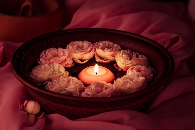 Spa relaxation - burned candle floating in rose water