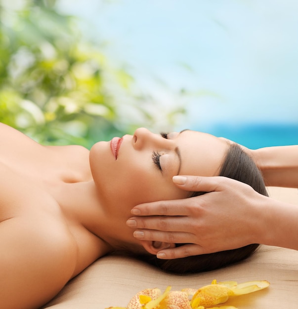 Photo spa, resort and beauty concept - calm beautiful woman in massage salon