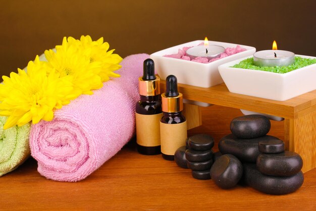 Spa setting on wooden table on brown background