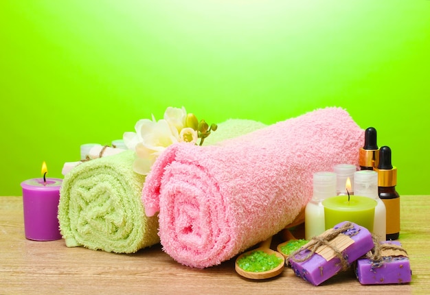 Spa setting on wooden table on green background