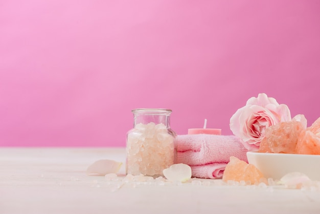 Spa settings with roses. Various items used in spa treatments on white wooden background.