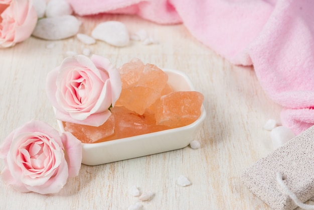 Spa settings with roses. Various items used in spa treatments on white wooden background.