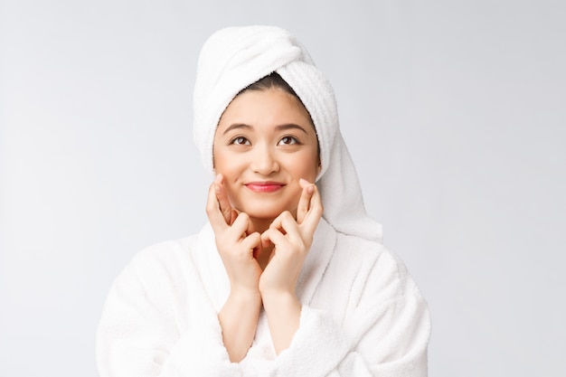 Bellezza cura della pelle spa donna asiatica asciugando i capelli con un asciugamano sulla testa dopo il trattamento doccia bella ragazza multirazziale toccando la pelle morbida