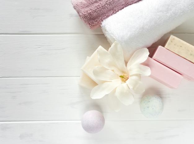 Banner di sapone spa. sapone naturale aromatico con fiori di magnolia e bomba da bagno su fondo bianco in legno, vista dall'alto