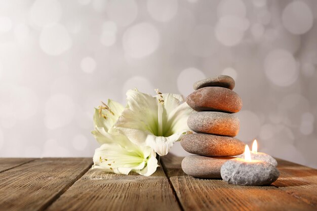 Foto spa stenen kaarsen en witte orchidee op houten tafel op lichte achtergrond