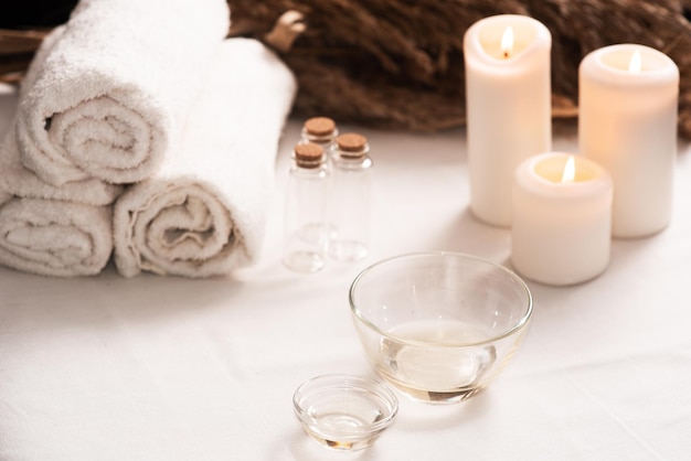 Spa still life with aromatic candlesoils and towel Dark background