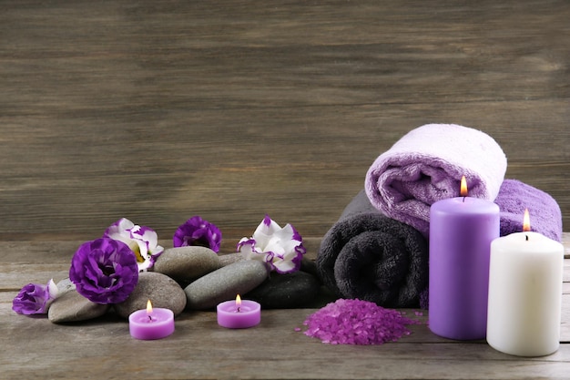 Spa stilleven met handdoeken paarse bloemen en kaarslicht op houten achtergrond