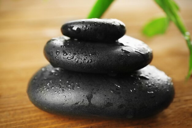 Spa stones and bamboo branch on wooden background