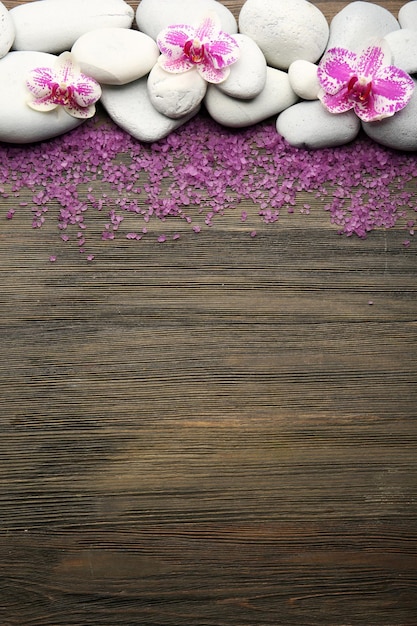 Foto pietre termali e orchidea su fondo di legno