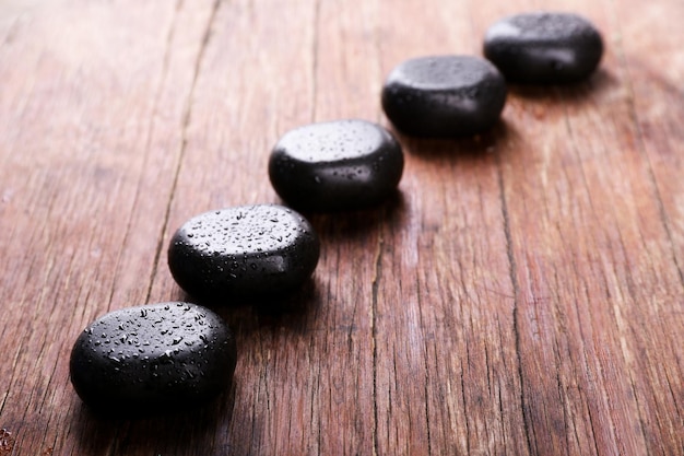 Photo spa stones with drops on wooden background