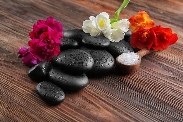 Photo spa stones with salt on wooden background