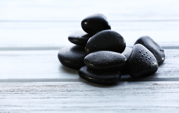 Photo spa stones with water drops on wooden background