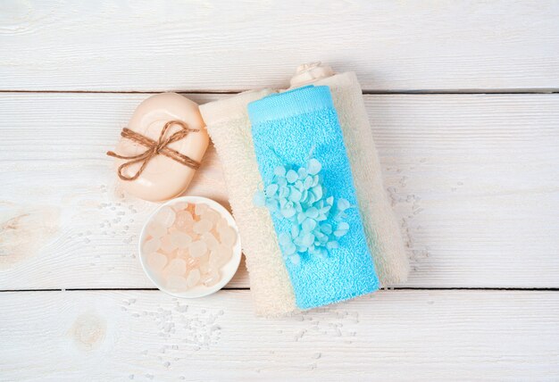 Photo spa supplies, soap and a towel with flowers.