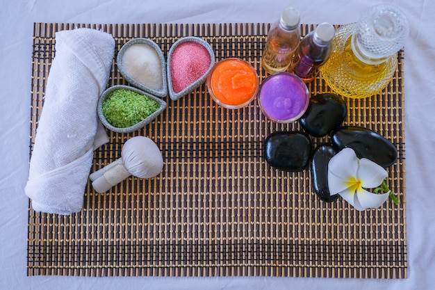 스파 트리트먼트 세트 및 침대 마사지에 아로마 마사지 오일. 아로마 테라피와 침대에 꽃과 함께 마사지를위한 태국 설정, 휴식과 건강 관리.