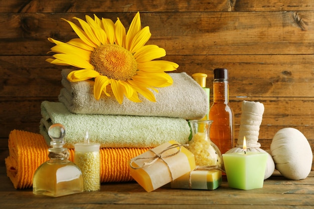 Spa treatments and sunflower on wooden background