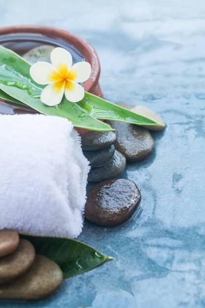 Foto fiore tropicale spa e oggetti per il trattamento di massaggio sano su sfondo blu