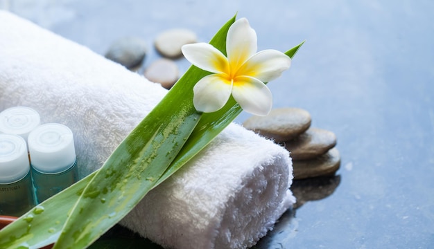 Spa tropical flowers with towel and cream tube Body care and spa concept